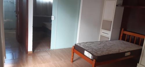 a small bedroom with a bed and a closet at Lunar in Palhoça