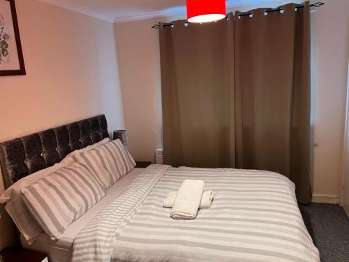 a bed with a white towel on top of it at Bec Chambers NE 1 in Cramlington