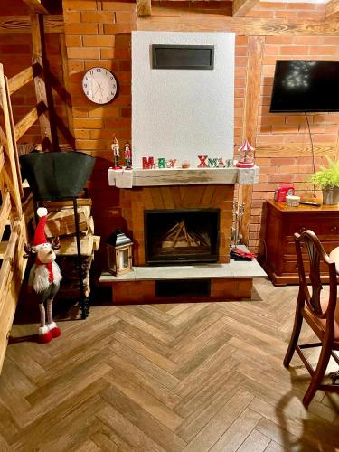 a living room with a fireplace and a clock at Twój Drugi Dom na Kaszubach in Załakowo