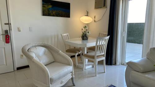 a living room with a white table and chairs at Hotel Du Lac Macaé in Macaé
