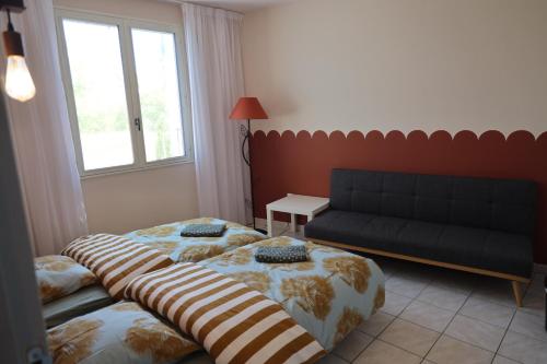 un salon avec deux lits et un canapé dans l'établissement Le Planol - Maison avec jardin et terrasse, à Alzonne