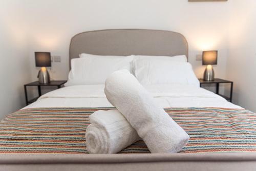 a bed with a rolled up towel on it at Your Home Away from Home in NWI