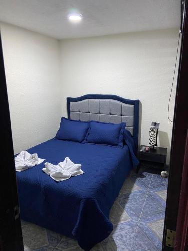 a bedroom with a blue bed with towels on it at Apartamento Paipa Boyacá "Las Quintas" in Paipa
