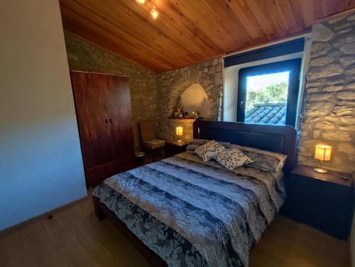 a bedroom with a bed and a stone wall at Casa rural Ca l'Antón in Sant Miquel de Campmajor