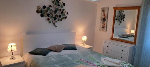 a bedroom with a bed with two lamps and a mirror at Isabel Dream I, 400m from the train in Rinchoa