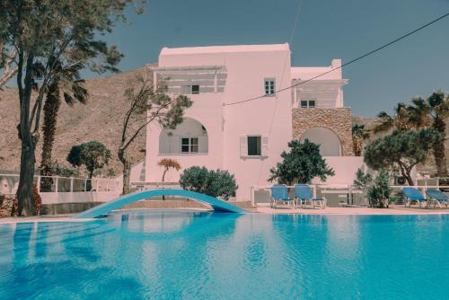 佩里萨Blue Island hotel Santorini的粉红色的房子,带一个游泳池,有蓝桥