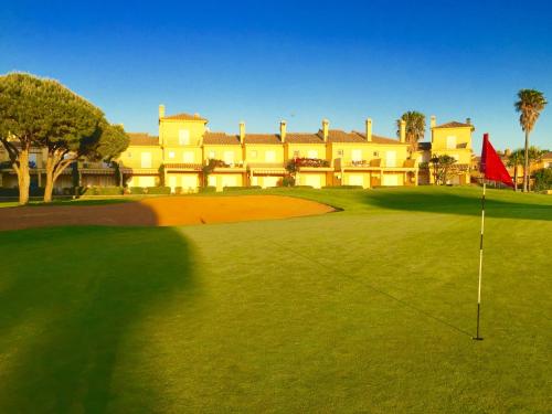 a golf course with a resort in the background at Novo Sancti Petri Green del 11 in Chiclana de la Frontera