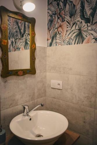 a bathroom with a sink and a mirror on the wall at Lawendowy Raj in Pilchowice