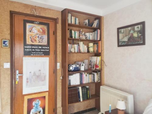a room with a book shelf filled with books at Chambre au calme sur les collines in Nice