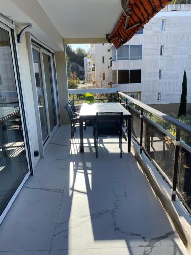 un patio avec une table et des chaises sur un balcon dans l'établissement Apartment Sea View with AC and Wifi, à Cassis