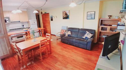 a living room with a couch and a table at Acogedor bajo con terraza y vistas in Nueva de Llanes