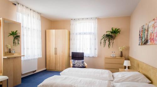 two beds in a room with two windows at Hotel Zum Grunewald in Dinslaken