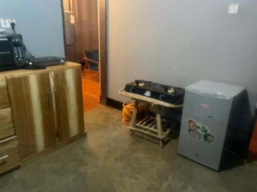 a kitchen with a stove and a refrigerator at Shambani Homestay in Moshi
