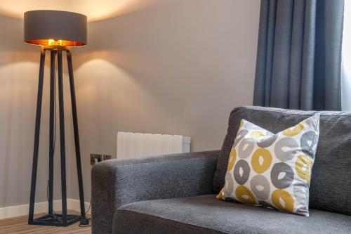 a lamp sitting next to a couch with a pillow at Garner Hotel Preston Samlesbury by IHG in Preston