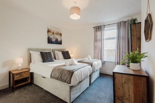 a bedroom with a large bed and a window at Free parking, late check out CoOp Live Etihad Stadium 3-bed house in Manchester