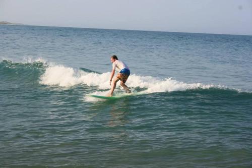 a man riding a wave on a surfboard in the ocean at Surf &Turf Arugam Bay in Arugam Bay
