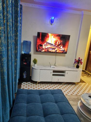 a living room with a tv on a wall at Very demure one bedroom with free parking in Nairobi