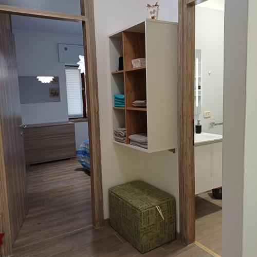 a bathroom with a mirror and a stool in a room at holiday home un piccolo angolo tra gnomi natura e relax in Tarvisio