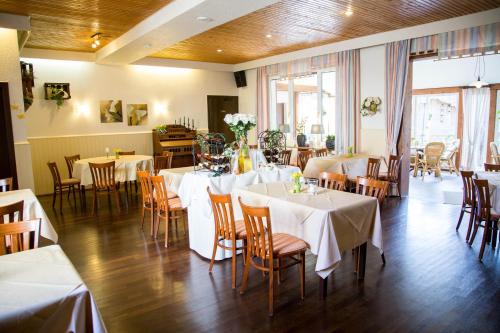 a restaurant with tables and chairs with white tablecloths at Hotel Zum Grunewald in Dinslaken