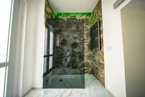 a walk in shower with a stone wall at Visula in Acireale