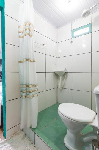 a bathroom with a toilet and a shower curtain at SunriseBelaVista Pousada e Flats in Paraty