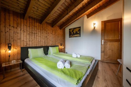 a bedroom with a green bed with towels on it at Half chalet with garden & balcony - 2' to Ski bus in Laax