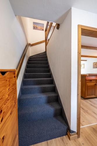 a staircase in a house with blue carpet at Half chalet with garden & balcony - 2' to Ski bus in Laax