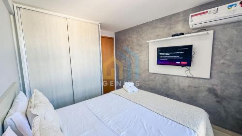 a bedroom with a bed and a tv on the wall at Eco Summer Tambaú WB Genius Flats in João Pessoa
