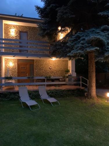 two chairs and a bench in front of a building at Baladise Apartman in Balatonvilágos