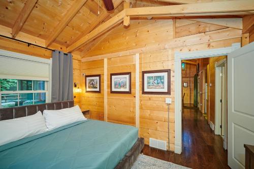 Un dormitorio con una cama en una habitación con paredes de madera. en Dollybrook 2 Pet Friendly Community Pool Groups Welcome, en Fennville