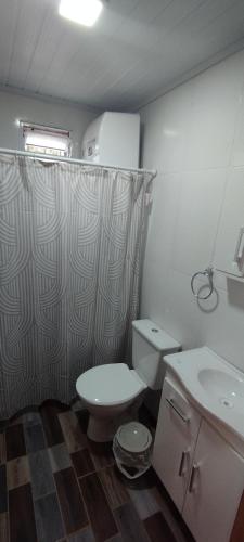a bathroom with a toilet and a sink at Cabañas del Sol in Punta Del Diablo