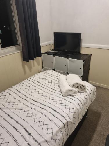 a bedroom with a bed with a television and a desk at JOE'S PLACE in Retford
