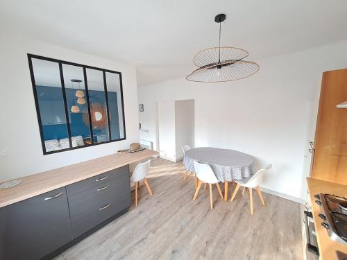 une cuisine et une salle à manger avec une table et des chaises dans l'établissement L'appart en hyper centre, à Challans