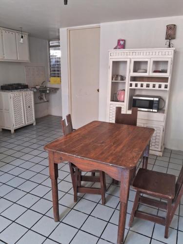 a kitchen with a wooden table and chairs at Casa de tres habitaciones por infonavit constituyentes in Uruapan del Progreso