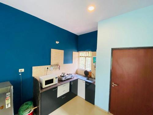a kitchen with blue walls and a brown door at V Square Villa in Shenwa