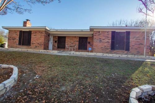 a brick house with a yard in front of it at The Wonder Inn - Sleeps 11 near TCU in Fort Worth