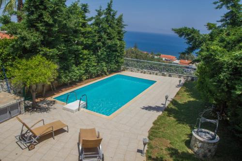 a swimming pool with a view of the ocean at Corinthian Residence in Melíssion