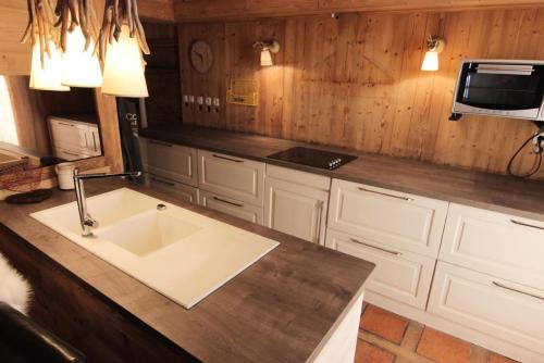 eine Küche mit einem Waschbecken und einem TV an der Wand in der Unterkunft Résidence Le Peclet - LE PECLET APPARTEMENT SPACIEUX ET TRES BEAU MAE-7441 in Val Thorens