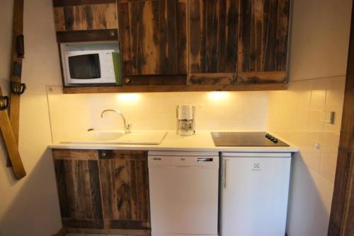 une petite cuisine avec un évier et un micro-ondes dans l'établissement Résidence Diamant - DIAMANT APPARTEMENT 50M² 6 PERS CENTRE STATION MAE-7461, à Val Thorens