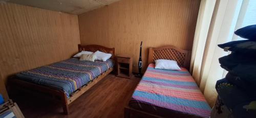 ein kleines Zimmer mit zwei Betten und einem Fenster in der Unterkunft Casa familiar con hermosa vista al mar in Las Cruces
