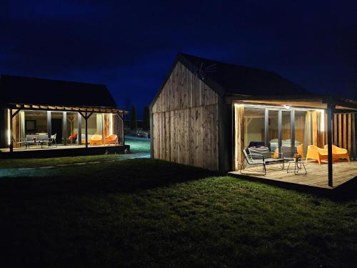 a large wooden house with a deck at night at Chata w Bieszczadzie apartamenty i domki z basenem Bieszczady in Polańczyk