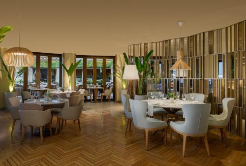 a restaurant with white tables and chairs and windows at Fairmont Rio de Janeiro Copacabana in Rio de Janeiro