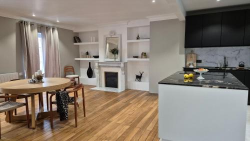 a kitchen and living room with a table and a dining room at Maison Lùisa in Autun