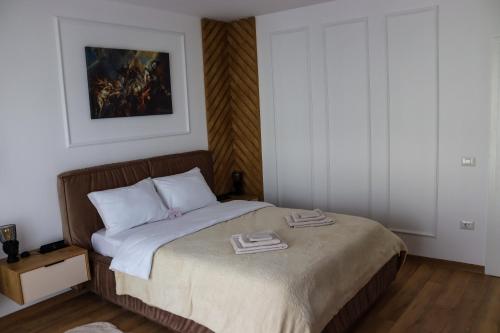 a bedroom with a bed with two towels on it at ApArte Suite in Râşnov