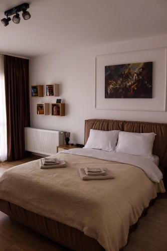 a bedroom with a large bed with two towels on it at ApArte Suite in Râşnov