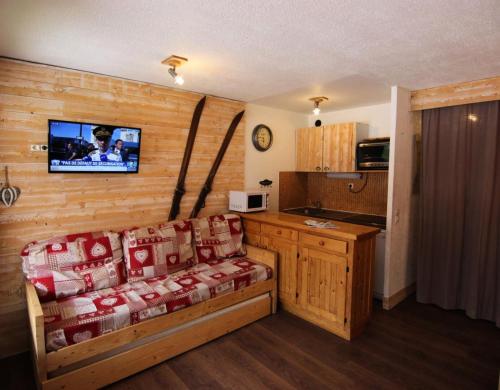 un salon avec un canapé et une télévision sur un mur dans l'établissement Résidence Neves - CHARMANT STUDIO 4 PERSONNES DANS LE QUARTIER ANIME DE LA STATION MAE-7704, à Val Thorens