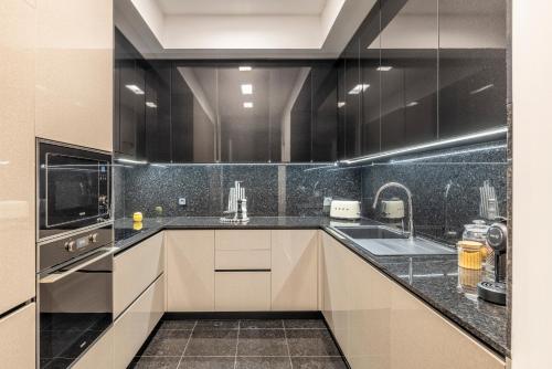 een keuken met een zwart-wit aanrecht en een wastafel bij Chãos Design By Minho's Guest in Braga