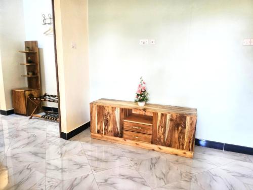 a room with a wooden cabinet with a plant on it at Safi House in Boma la Ngombe