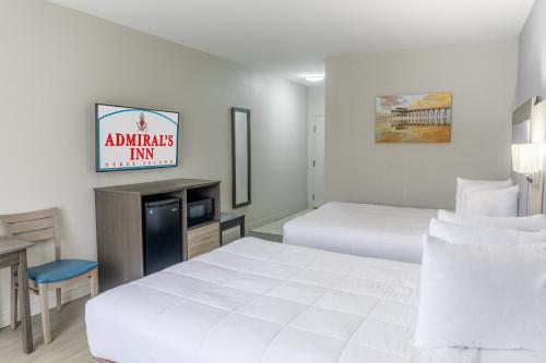 a hotel room with two beds and a tv at Admiral's Inn on Tybee Island in Tybee Island