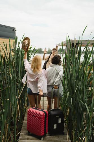 a group of three girls standing with their luggage at Costa del Kryspi Całoroczne Domy na Wodzie in Cholerzyn